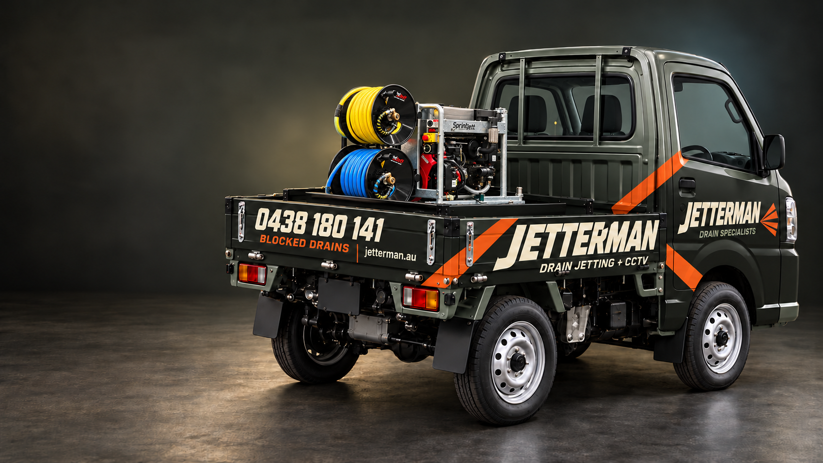 Suzuki Carry with a charcoal and orange Jetterman wrap and compact stacked yellow and blue jetter hose reels