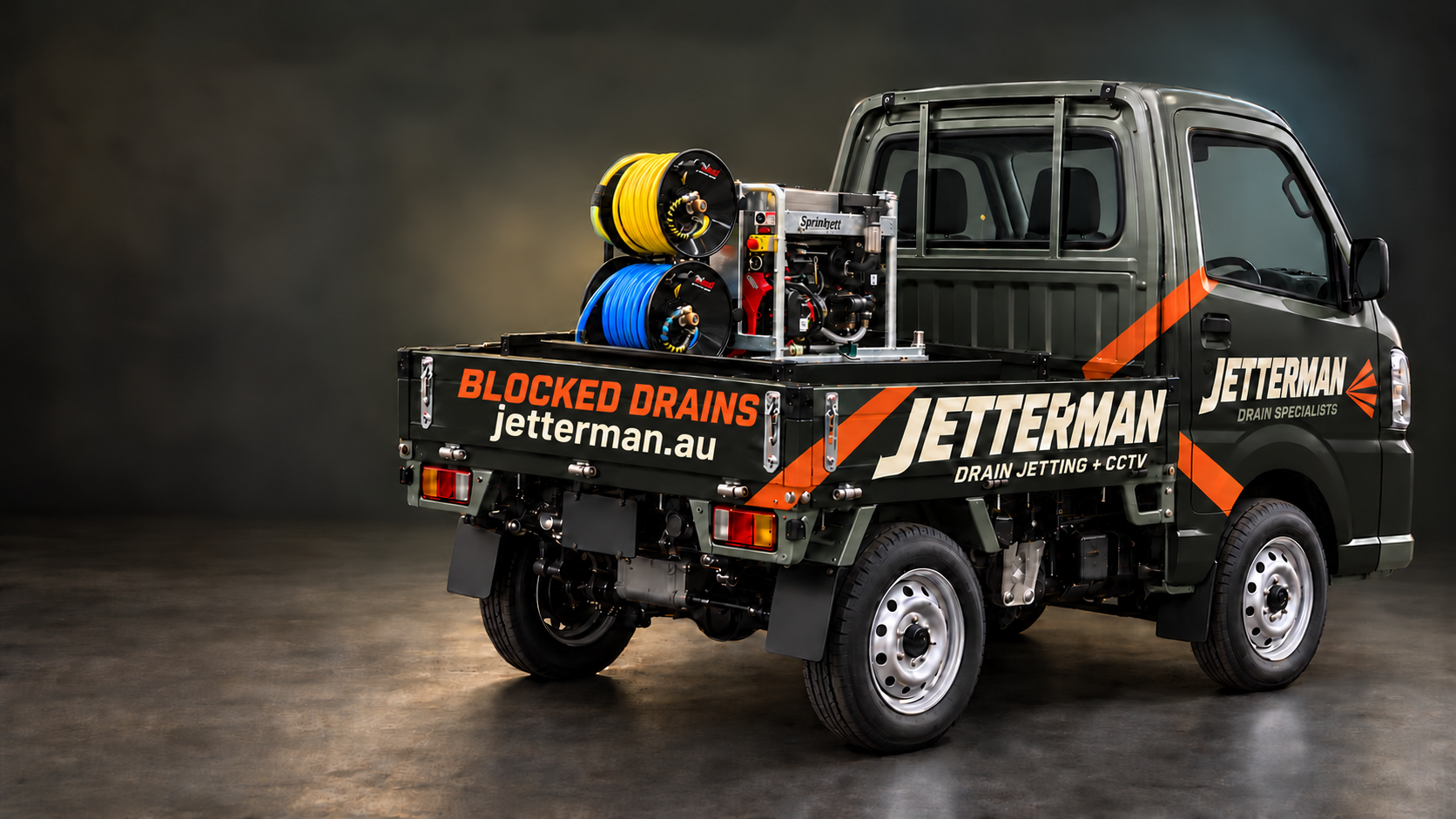 Suzuki Carry with a charcoal and orange Jetterman wrap and compact stacked yellow and blue jetter hose reels