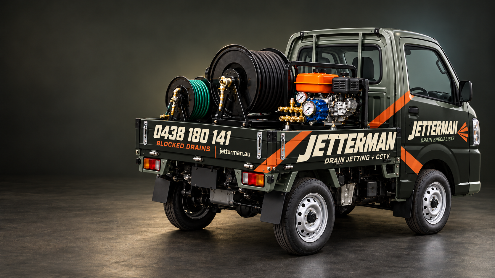 Suzuki Carry with a charcoal and orange Jetterman wrap, high-pressure pump and hose reels